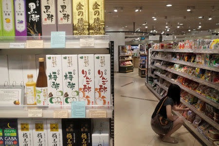 A woman shops next to a shelf of Japanese vinegar at a supermarket in Singapore October 6, 2016. REUTERS/Edgar Su