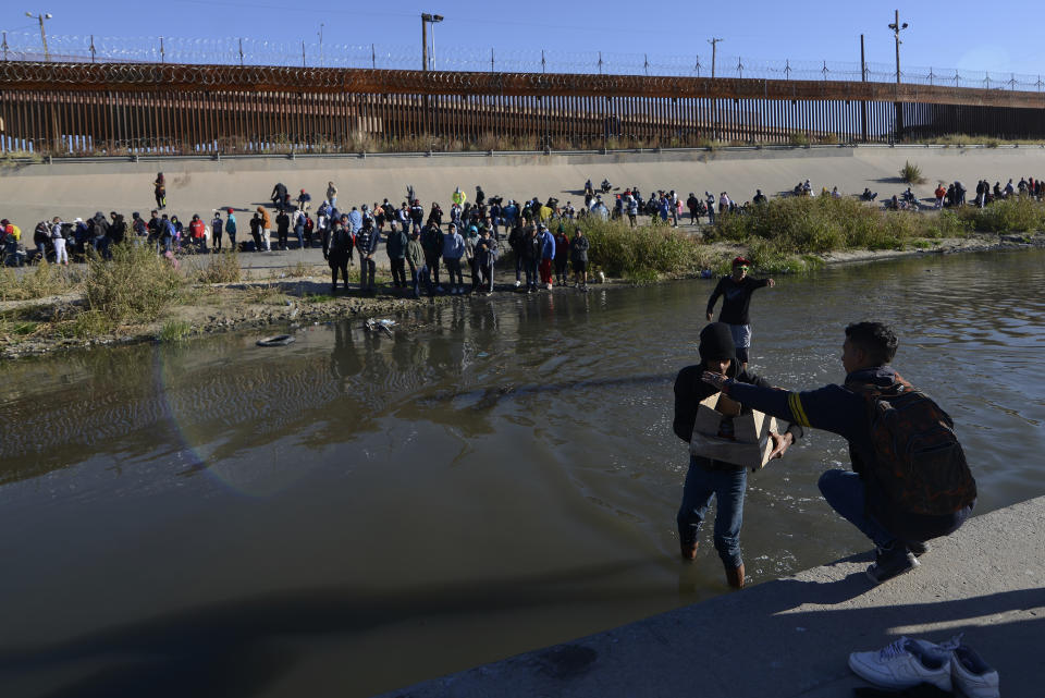 Migrants cross the Mexico-U.S. border to surrender to U.S. Border Patrol agents, in Ciudad Juarez, Mexico, Monday, Dec. 12, 2022. According to the Ciudad Juarez Human Rights Office, hundreds of mostly Central American migrants arrived in buses and crossed the border to seek asylum in the U.S., after spending the night in shelters. (AP Photo/Christian Chavez)