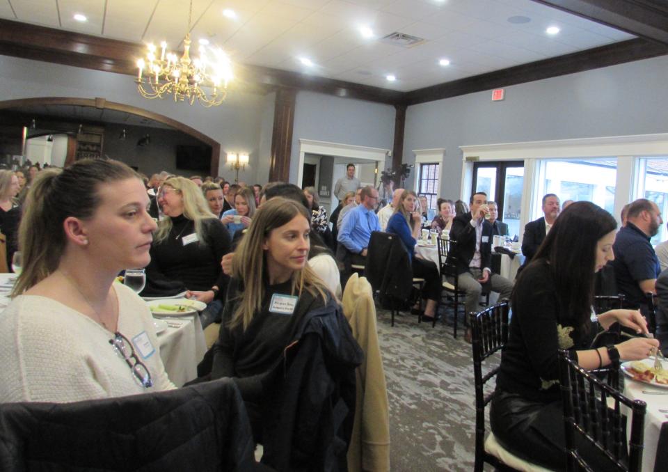 Guests at the State of the City watch as Thomas Sheridan, the city manager, relates the high points of 2023 in Hudson.