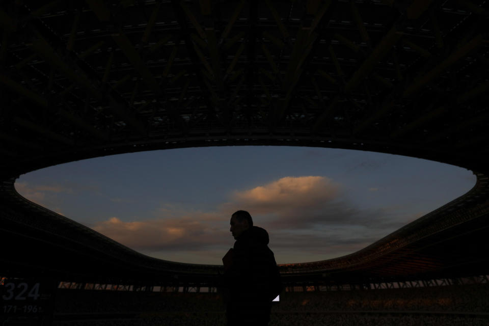 A man is silhouetted against the sky during a tour at the new National Stadium Sunday, Dec. 15, 2019, in Tokyo. The stadium is officially completed. (AP Photo/Jae C. Hong)