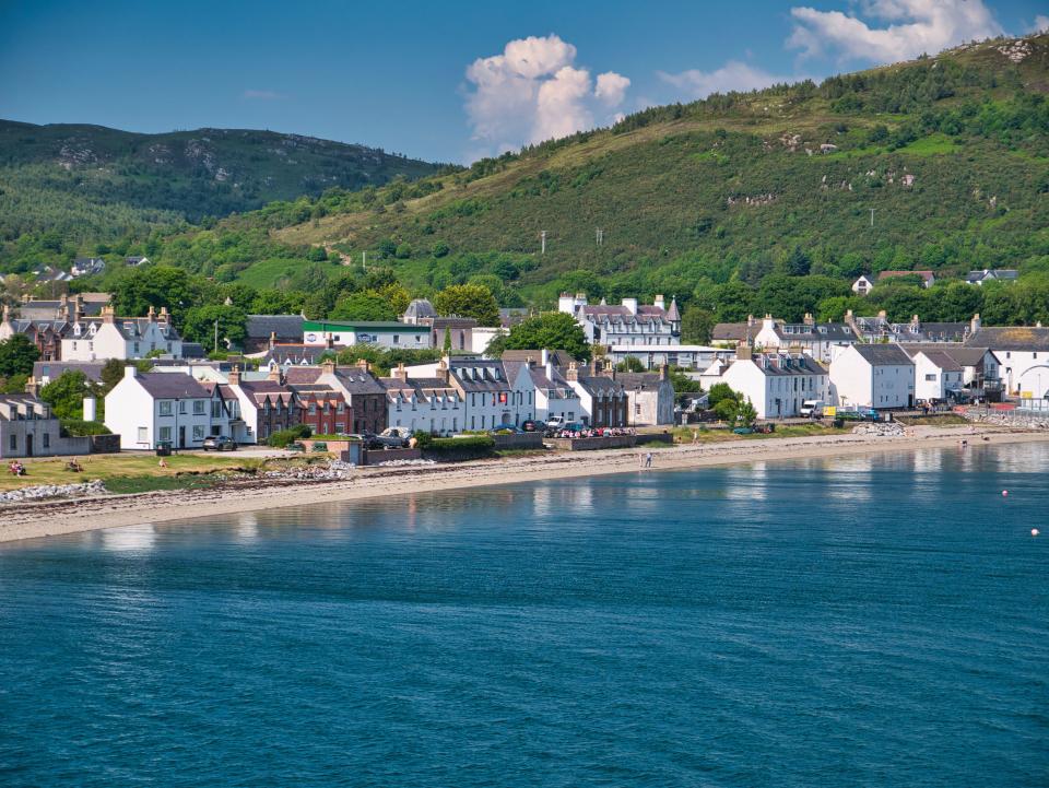 retire Beachside houses and other buildings at the port of Ullapool in Scotland, UK. Taken from the arriving ferry from Stornoway on a clear, sunny afternoon