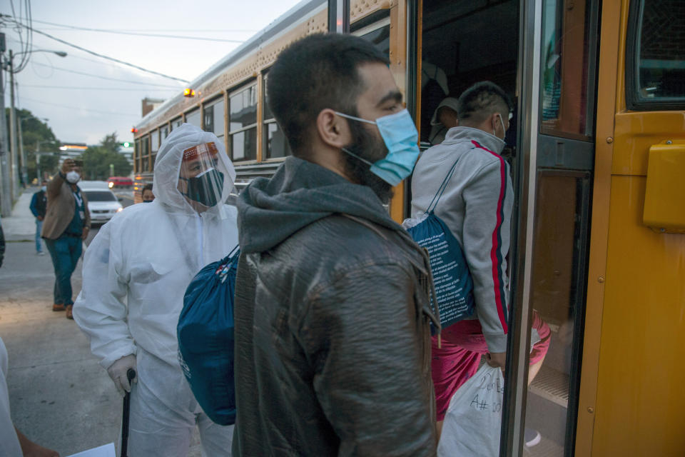 Guatemalans deported from the U.S., wearing a mask as a precaution against the spread of the new coronavirus, board a bus after arriving at La Aurora airport in Guatemala City, Tuesday, June 9, 2020. The United States resumed deportation flights to Guatemala, nearly a month after the Central American country refused to accept them. (AP Photo/Moises Castillo)