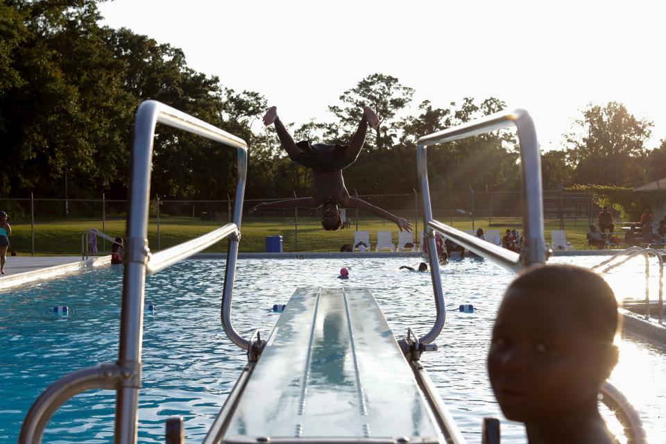 Kanye Ramos, 11, does a flip off the end of the diving board into the pool during Splash and Jam at the Walker-Ford Community Center Friday, July 26, 2019. 