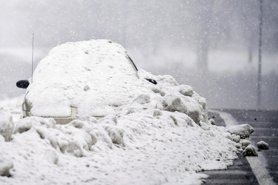 An abandoned car is covered in snow on the shoulder of Briley Parkway in Nashville, Tennessee, February 18. Source: The Tennessean via AP