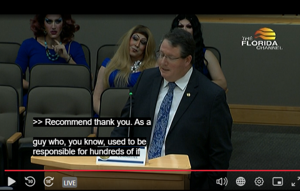 House bill sponsor Randy Fine, R-Palm Bay, presents the bill Friday, March 24, 2023, in the Commerce Committee as several drag queens seated behind him watch the proceedings.