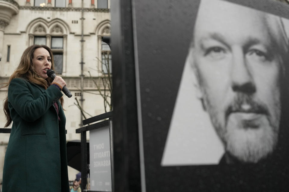 Stella Assange, wife of Julian Assange, speaks besides a poster of Julian Assange at the Royal Courts of Justice in London, Wednesday, Feb. 21, 2024. Julian Assange's lawyers are on their final U.K. legal challenge to stop the WikiLeaks founder from being sent to the United States to face spying charges. The 52-year-old has been fighting extradition for more than a decade, including seven years in self-exile in the Ecuadorian Embassy in London and the last five years in a high-security prison. (AP Photo/Kin Cheung)