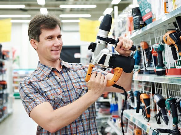 Man in a home improvement store examining a power tool