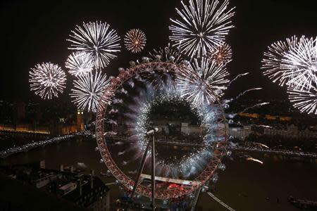 Fireworks explode across a London skyline near the London Eye during New Year celebrations in London January 1, 2014. REUTERS/Olivia Harris