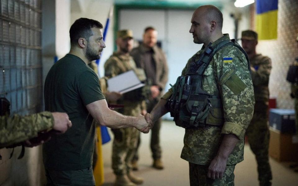 Ukrainian President Volodymyr Zelensky shakes hands with a Ukrainian serviceman during his visit to the frontline positions of the army in Bakhmut and Lysychansk districts, on June 6, 2022. - Ukrainian Presidential Press Service/AFP