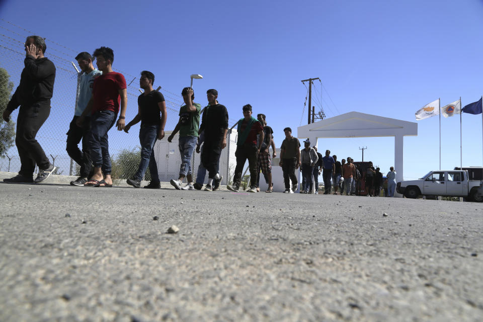 FILE - Migrants from Syria walk towards a refugee camp at Kokkinotrimithia, outside of the capital Nicosia, in the eastern Mediterranean island of Cyprus on Sunday, Sept. 10, 2017. Cyprus has formally called on the European Union to re-evaluate which areas of Syria can be declared safe and free from armed conflict so that Syrian migrants can eventually be repatriated there, the Cypriot Interior Ministry said Friday, Sept. 22, 2023. (AP Photo/Petros Karadjias, File)