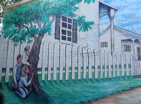 A hand-painted mural showing a scene of the 1960 bestseller " To Kill A Mockingbird" is shown on a building near where the homes of 1960's writers Harper Lee and Truman Capote's homes once stood in Monroeville, Alabama October 23, 2013. Lee, the 87-year-old author of the still-popular 1960 bestseller, recently filed a lawsuit against the museum dedicated to her novel in a dispute over a merchandising trademark. Photo taken October 23, 2013. REUTERS/Verna Gates