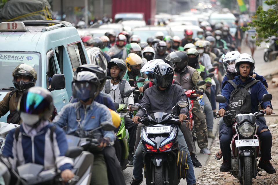 People ride motorcycles to their home village, leaving from Jakarta, Indonesia, Wednesday, April 19, 2023. The mass exodus out of Jakarta and other major cities in the world's most populous Muslim country is underway as millions are heading home to their villages to celebrate Eid al-Fitr holiday that marks the end of the holy fasting month of Ramadan. (AP Photo/Achmad Ibrahim)