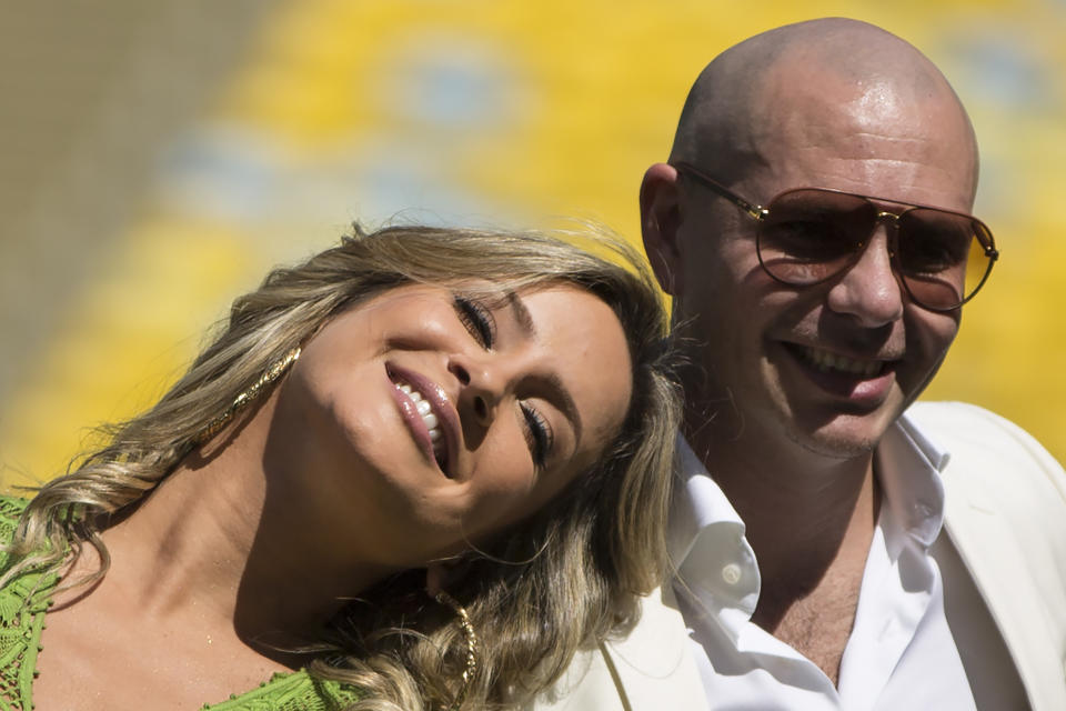 Brazilian singer Claudia Leitte and rapper Pitbull pose at the Maracana stadium in Rio de Janeiro, Brazil, Thursday, Jan. 23, 2014. Claudia Leitte and Pitbull will perform with Jennifer Lopez the official song for the 2014 World Cup. Football's governing body didn't elaborate when the song, written and co-produced by Pitbull will be released. (AP Photo/Felipe Dana)