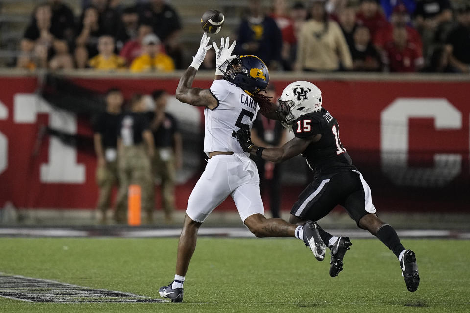 West Virginia wide receiver Devin Carter (5) makes a reception against Houston defensive back Malik Fleming (15) during the third quarter of an NCAA college football game Thursday, Oct. 12, 2023, in Houston. (AP Photo/Kevin M. Cox)