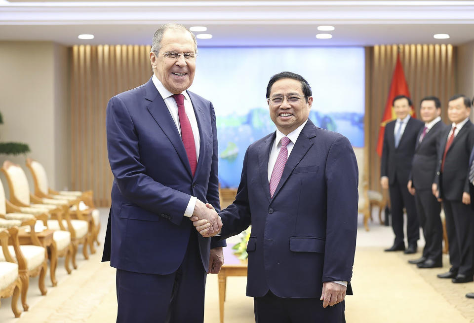 Russian Foreign Minister Sergey Lavrov and Vietnamese Prime Minister Pham Minh Chinh shake hands in Hanoi, Vietnam on Wednesday, July 6, 2022. (Duong Van Giang/VNA via AP)