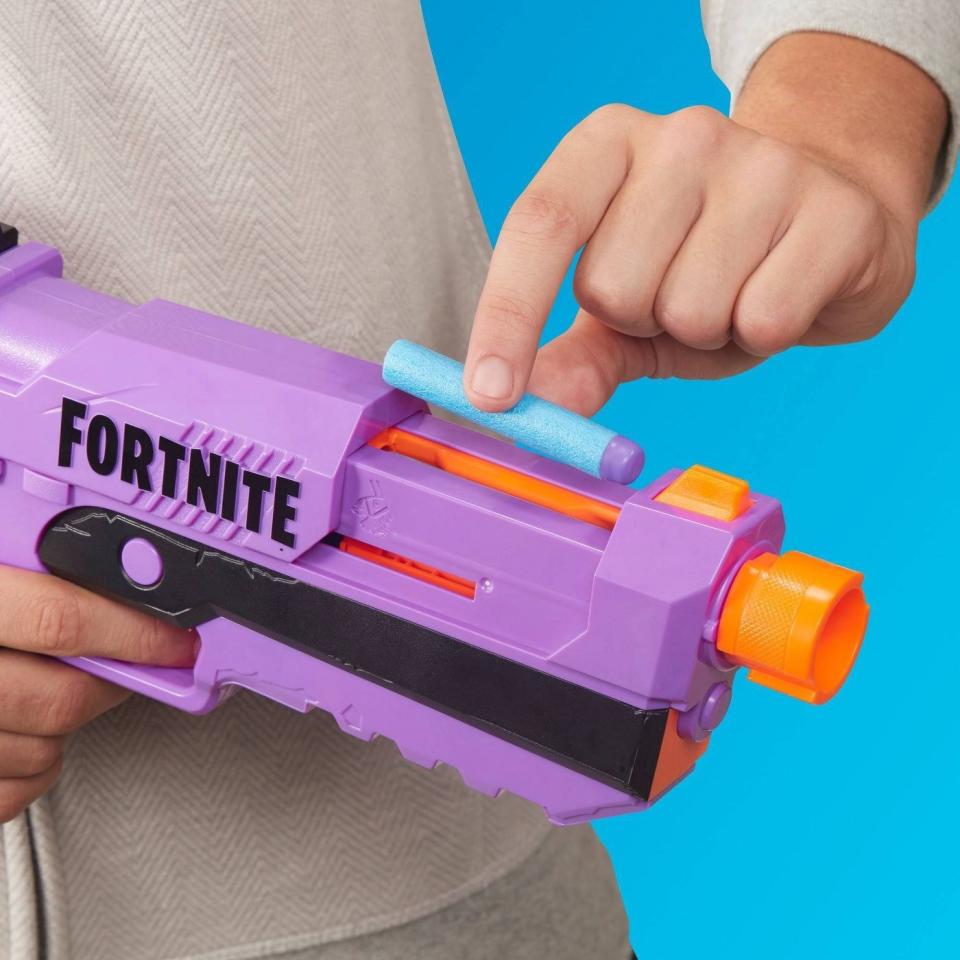 a model loading the nerf gun with a foam nerf dart