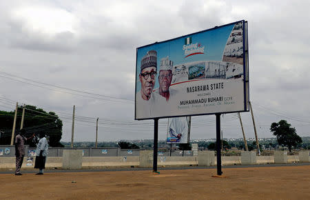Men stand near a billboard depicting Nigeria's President Muhammadu Buhari in Nasarawa State, Nigeria April 12, 2018. REUTERS/Afolabi Sotunde