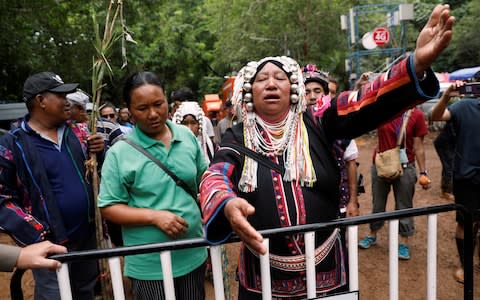 An ethnic Akha woman prays for the return of the missing members of an under-16 soccer team - Credit: Reuters