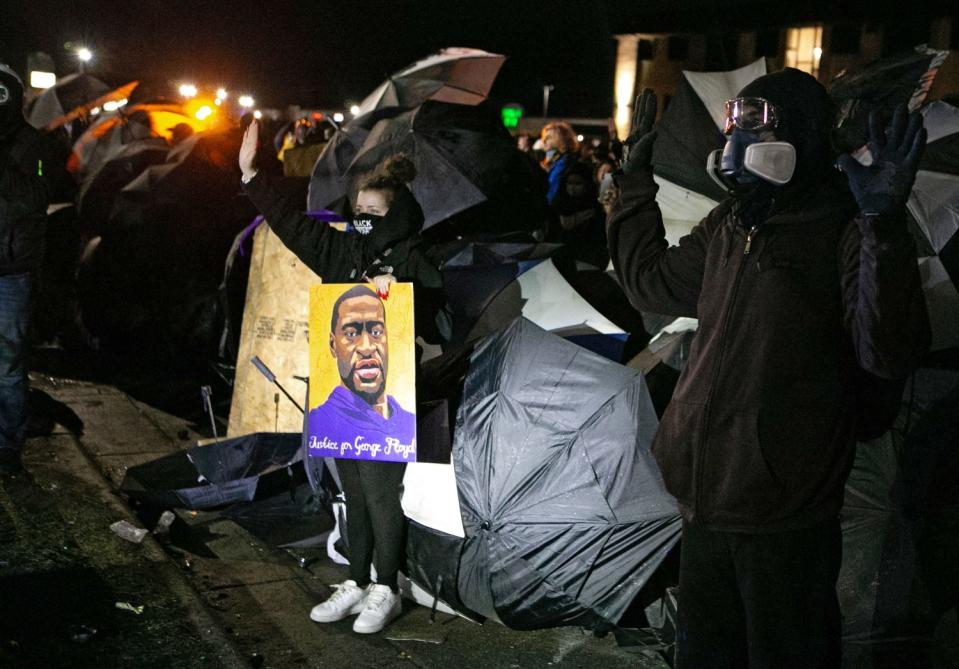 Demonstrators with umbrellas.