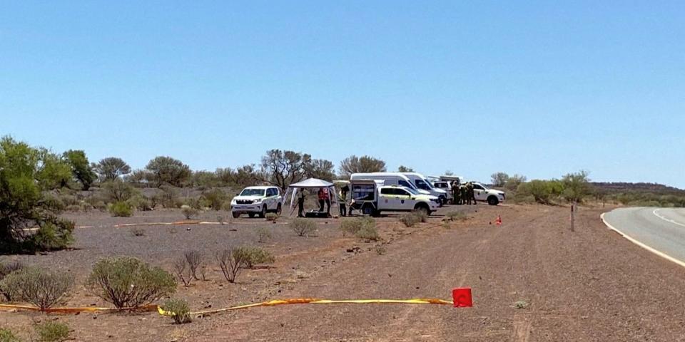 A view of the roadside search area, partially cordoned off, for a radioactive pellet in Western Australia, on February 1 2023. Scene is a sunny desert landscape with a few vehicles a blue sky