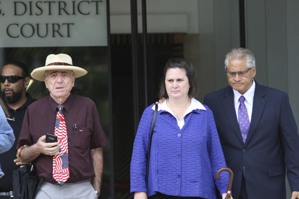 Former Honolulu police chief Louis Kealoha, right, his wife, former deputy prosecutor Katherine Kealoha, center, and her attorney Earle Partington, left, walk out of federal court in Honolulu on Tuesday, June 25, 2019. Prosecutors say the couple abused their positions in an attempt to silence a relative who could have exposed the financial fraud that funded their lavish lifestyle. Closing arguments were being held Tuesday in the conspiracy trial against the Kealoha's, considered the largest public corruption trial ever in Hawaii. (AP Photo/Caleb Jones)