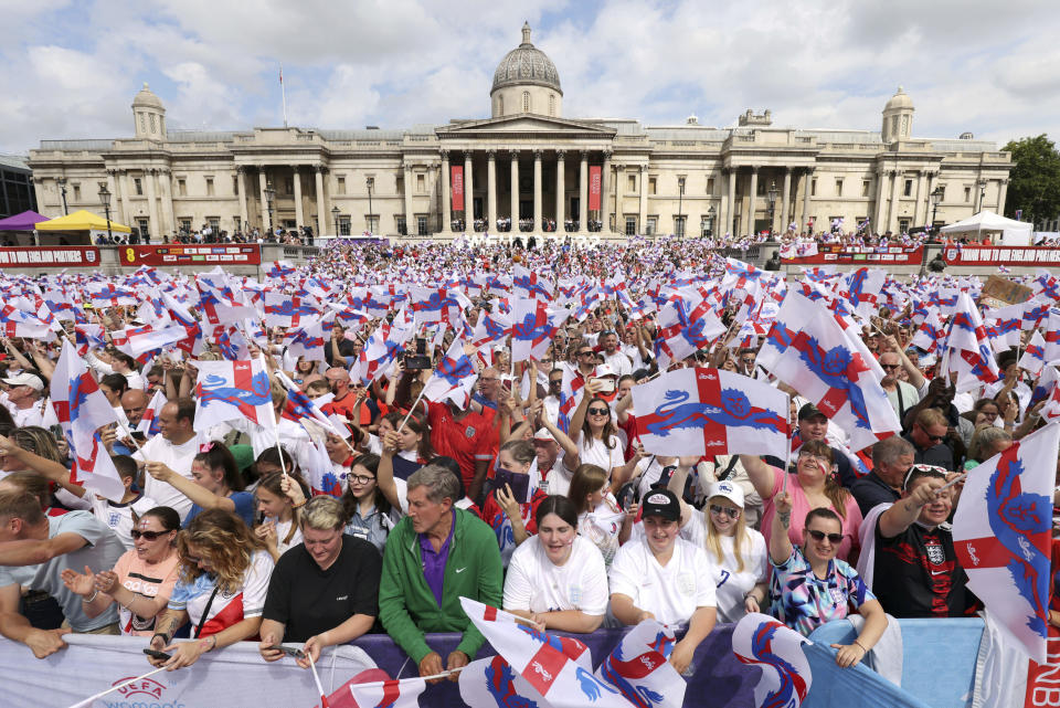 England supporters wave flags as they wait for the arrival of their national soccer team at Trafalgar Square in London, Monday, Aug. 1, 2022. England beat Germany 2-1 and won the final of the Women's Euro 2022 on Sunday. (James Manning/PA via AP)