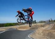 U.S. Olympic BMX athlete Connor Fields (R) goes over a jump as he trains with New Zealand's Trent Jones at the Olympic Training Center in Chula Vista, California, United States, July 23, 2016. REUTERS/Mike Blake