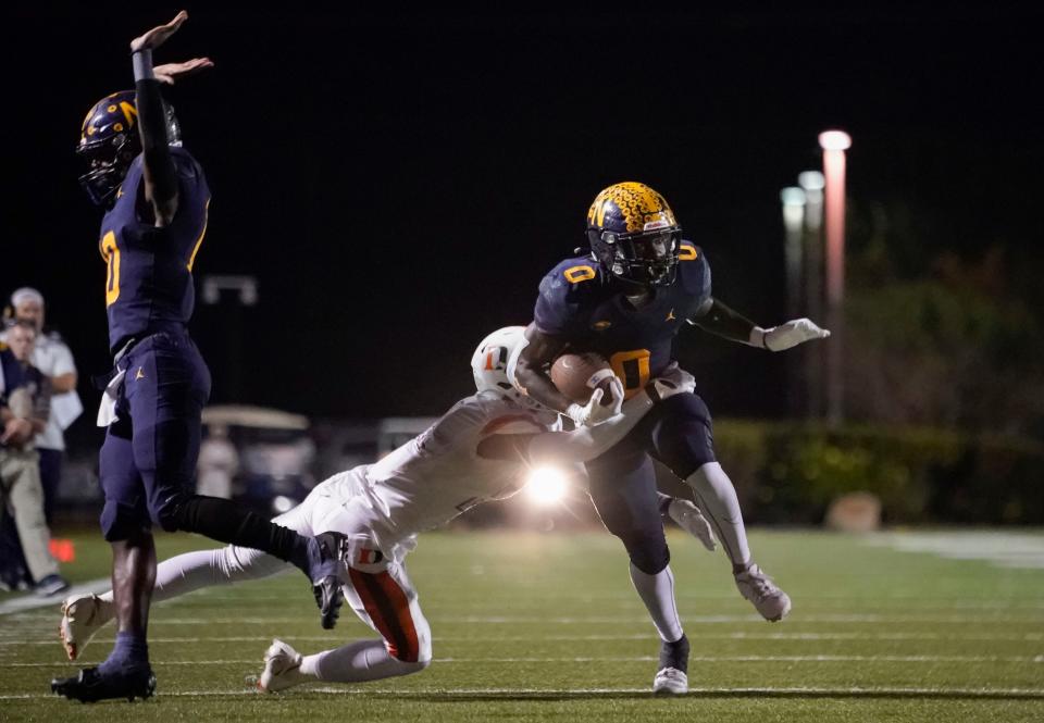 Naples Golden Eagles running back Kendrick Raphael (0) tries to break a tackle from a Dunbar Tigers defender during the second half of the Class 3S regional 4 final at Staver Field in Naples on Friday, Nov. 25, 2022.