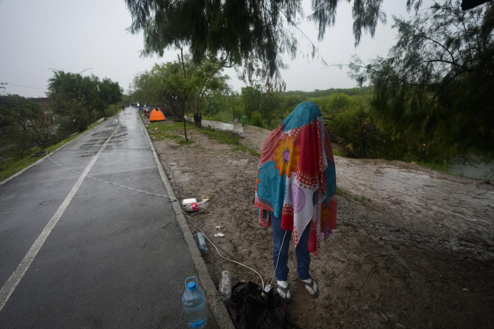 A Venezuelan migrant stands covered in a wrap while texting, on the banks of the Rio Grande in Matamoros, Mexico, Saturday, May 13, 2023. The image was part of a series by Associated Press photographers Ivan Valencia, Eduardo Verdugo, Felix Marquez, Marco Ugarte Fernando Llano, Eric Gay, Gregory Bull and Christian Chavez that won the 2024 Pulitzer Prize for feature photography. (AP Photo/Fernando Llano)