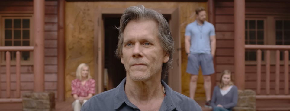 A man stands before a crowd of people at a camp