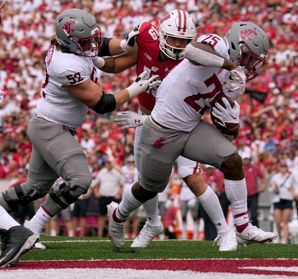 Washington State running back Nakia Watson breaks through the Wisconsin line for a touchdown during the second quarter Saturday at Camp Randall Stadium in Madison.