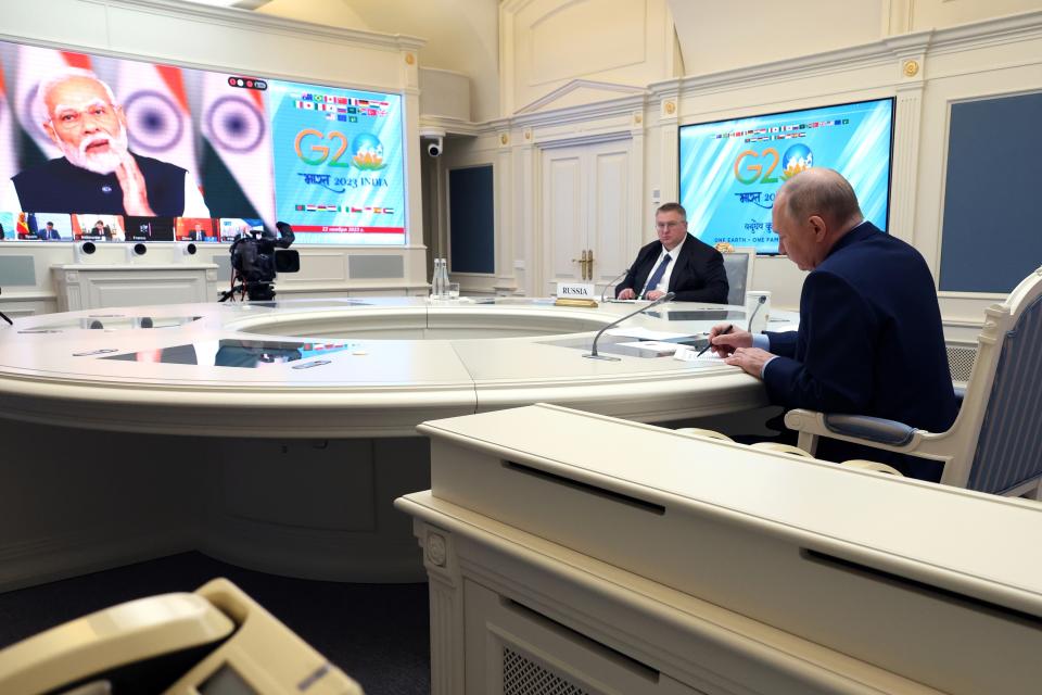 Russian President Vladimir Putin, right, and Russian Deputy Prime Minister Alexey Overchuk, second right, attend an extraordinary G20 summit via videoconference as Indian Prime Minister Narendra Modi is seen on the screen in Moscow, Russia, Wednesday, Nov. 22, 2023. (Mikhail Klimentyev, Sputnik, Kremlin Pool Photo via AP)