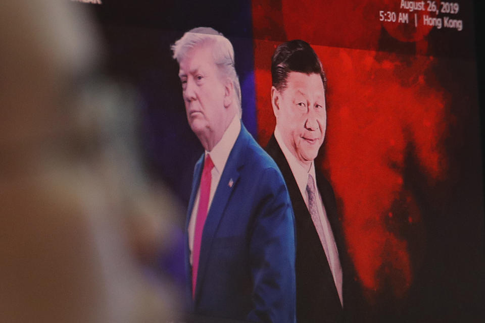 A computer screen shows images of Chinese President Xi Jinping, right, and U.S. President Donald Trump as a currency trader works at the foreign exchange dealing room of the KEB Hana Bank headquarters in Seoul, South Korea, Monday, Aug. 26, 2019. Asian shares tumbled Monday after the latest escalation in the U.S.-China trade war renewed uncertainties about global economies, as well as questions over what Trump might say next. (AP Photo/Ahn Young-joon)