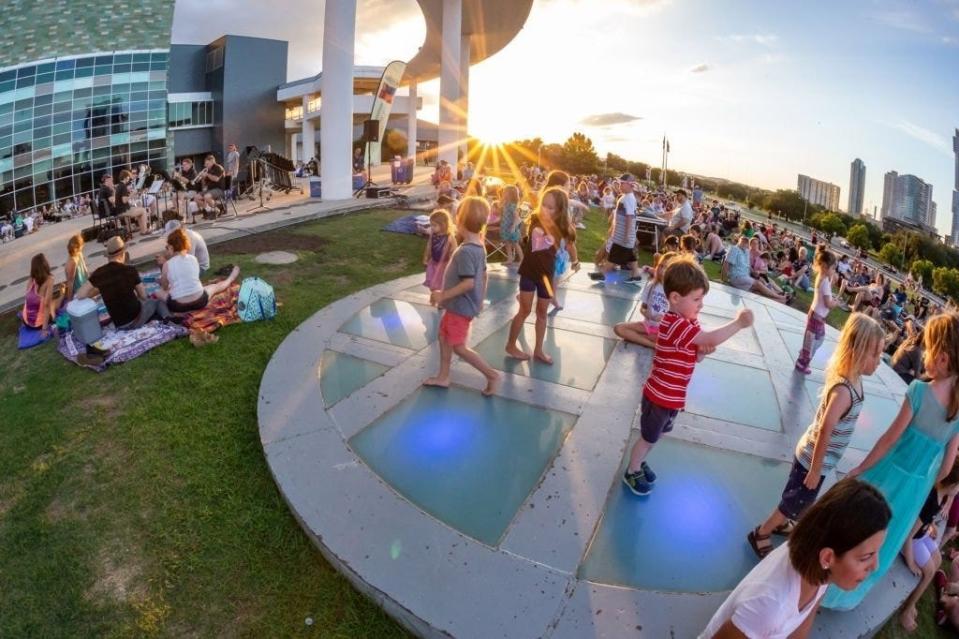 Children play at the Long Center during an Austin Symphony Orchestra concert in the park. The symphony presents small group performances most Sundays during the summer.