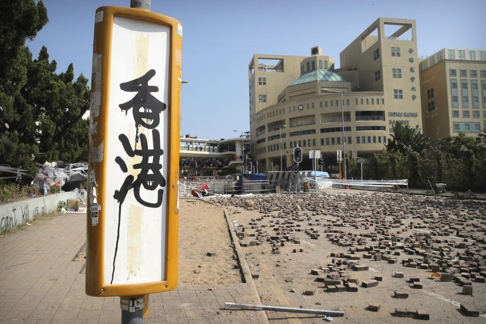 Graffiti reading "Hong Kong" is sprayed on a bus stop near barricades built by protesters at Hong Kong Baptist University in Hong Kong, Friday, Nov. 15, 2019. Protesters who have barricaded themselves in a Hong Kong university partially cleared a road they were blocking and demanded that the government commit to holding local elections on Nov. 24. (AP Photo/Kin Cheung)