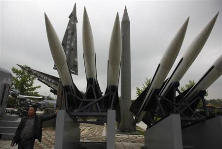 A visitor poses for a photo next to a display of mock South Korean U.S.-made Hawk surface-to-air missiles and a mock North Korean Russian-made Scud-B ballistic missile (C, in gray), at the Korean War Memorial Museum in Seoul May 20, 2013. REUTERS/Kim Hong-Ji