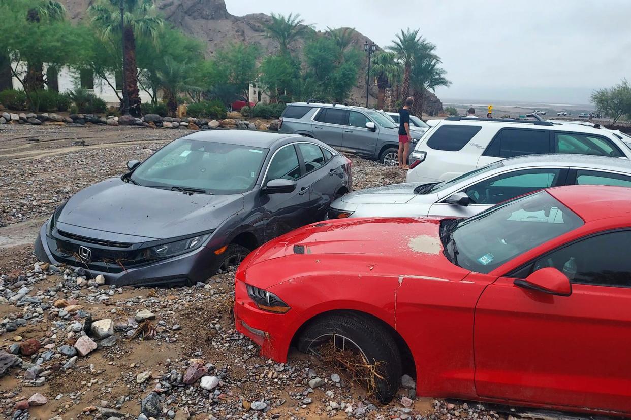 In this photo provided by the National Park Service, cars are stuck in mud and debris from flash flooding at The Inn at Death Valley in Death Valley National Park, Calif., Friday, Aug. 5, 2022.