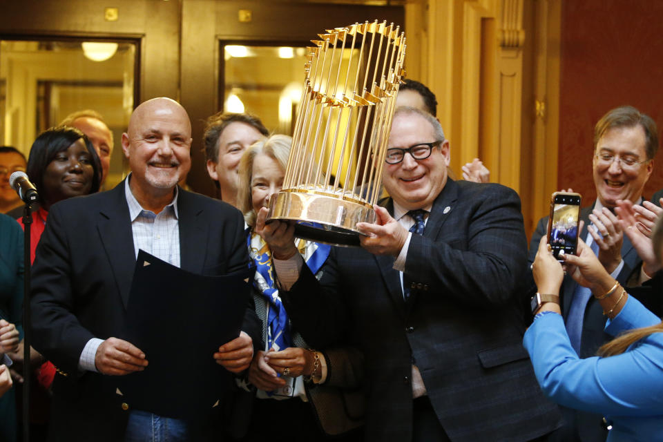 Del. Mark Sickles, D-Fairfax., right, holds the Washington Nationals World Series trophy as Nationals president and General Manager, Mike Rizzo, left, looks on as the Virginia House of Delegates honors the team during the session at the Capitol Tuesday Jan 28, 2020, in Richmond, Va. (AP Photo/Steve Helber)
