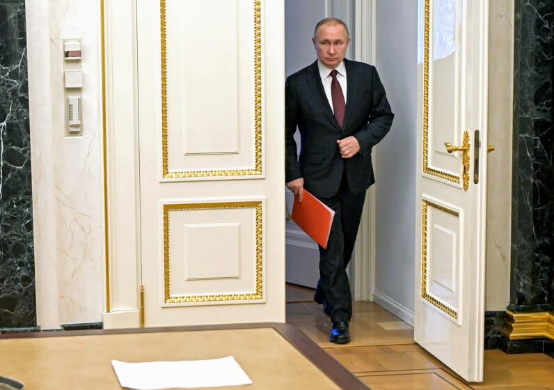 Russian President Vladimir Putin enters a hall to chair a Security Council meeting in Moscow, Russia, Friday, Feb. 25, 2022.