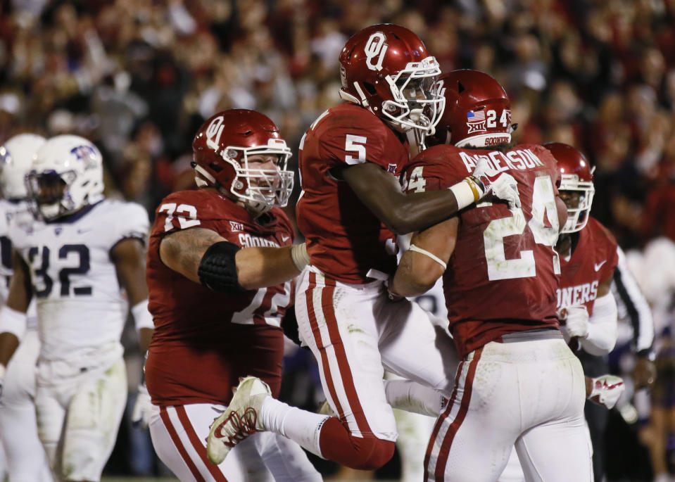 Oklahoma running back Rodney Anderson (24) celebrates a touchdown with teammates Marquise Brown (5) and Ben Powers (72) in the second quarter of an NCAA college football game against TCU in Norman, Okla., Saturday, Nov. 11, 2017. (AP Photo/Sue Ogrocki)