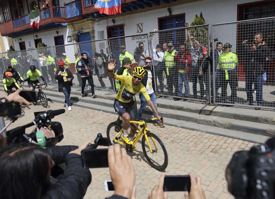 Tour de France winner Egan Bernal waves to the crowd as he is welcomed home to Zipaquira, Colombia, Wednesday, Aug. 7, 2019. Bernal rode into the town's central square on his bike on wearing the Tour de France's iconic yellow jersey. A group of some 3,000 supporters dressed in the same color chanted his name. (AP Photo/Ivan Valencia)