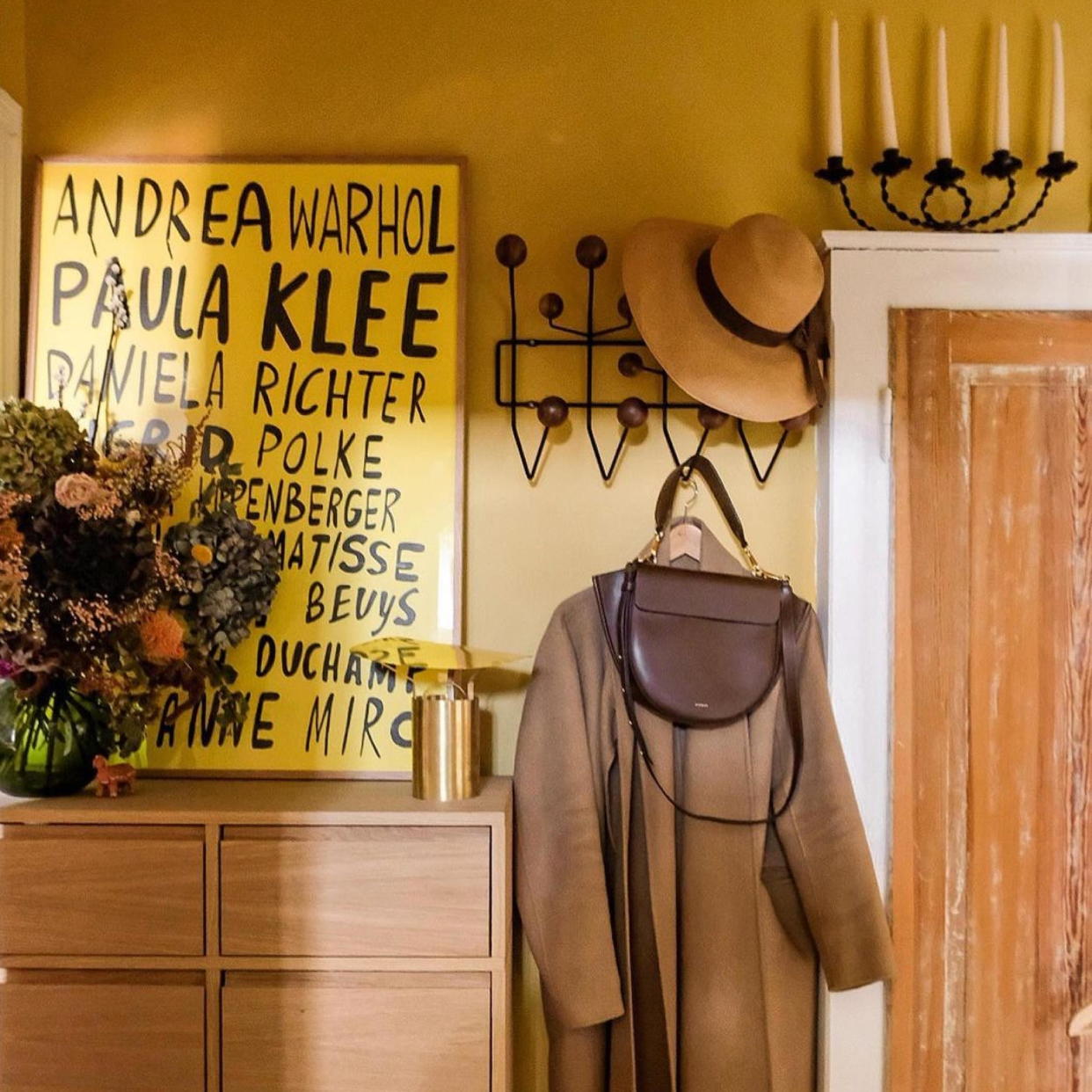  Hallway with yellow wall and hooks for coat. 