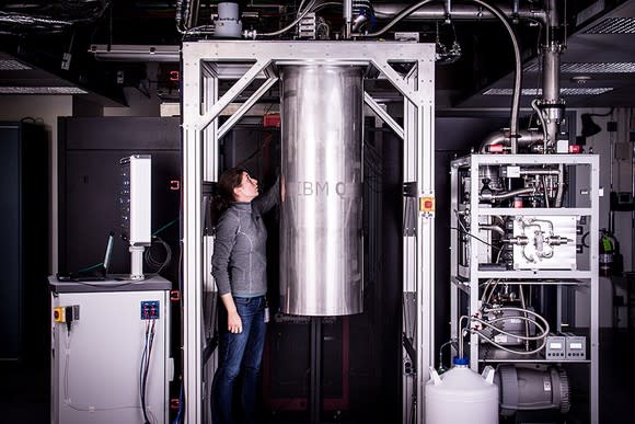 A woman standing next to an IBM Q prototype quantum system.