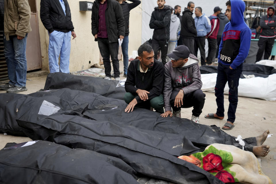 Palestinians morn by the bodies of their relatives killed in the Israeli bombardments of the Gaza Strip in front of the morgue to pray over them at Al Aqsa Hospital in Deir al Balah on Friday, Feb. 23, 2024. (AP Photo/Adel Hana)