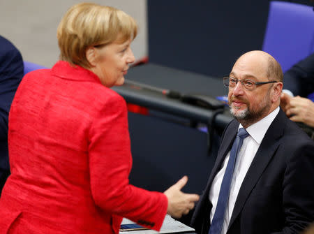 German Chancellor Angela Merkel speaks with Social Democratic Party (SPD) leader Martin Schulz as they attend a meeting of the Bundestag in Berlin, Germany, November 21, 2017. REUTERS/Axel Schmidt