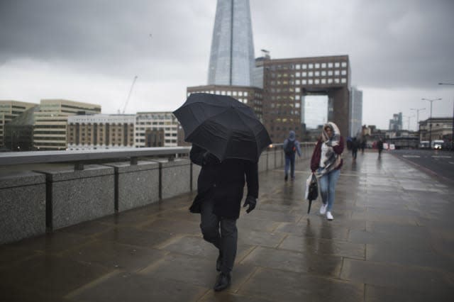 Crossing London Bridge Struggling With An Umbrella