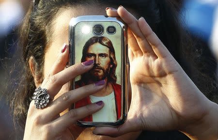 A Catholic faithful takes a picture with a mobile phone before Pope Francis arrives to lead mass in Colombo, January 14, 2015. REUTERS/Stefano Rellandini