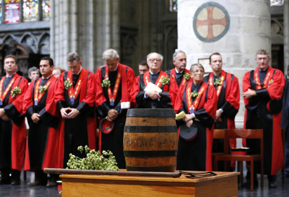 Members of the Knighthood of the Brewers' Mash staff attend a mass in front of a barrel of beer at the Sint-Gudule Cathedral in Brussels