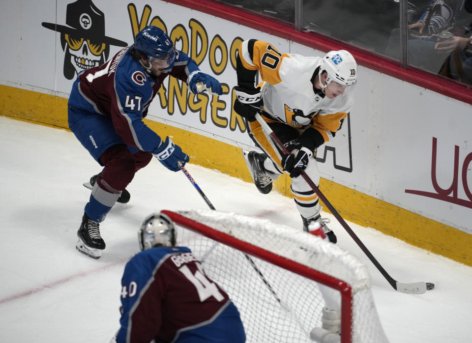 Pittsburgh Penguins left wing Drew O'Connor, right, collects the puck as Colorado Avalanche forward Alex Galchenyuk defends in the first period of an NHL hockey game Wednesday, March 22, 2023, in Denver. (AP Photo/David Zalubowski)