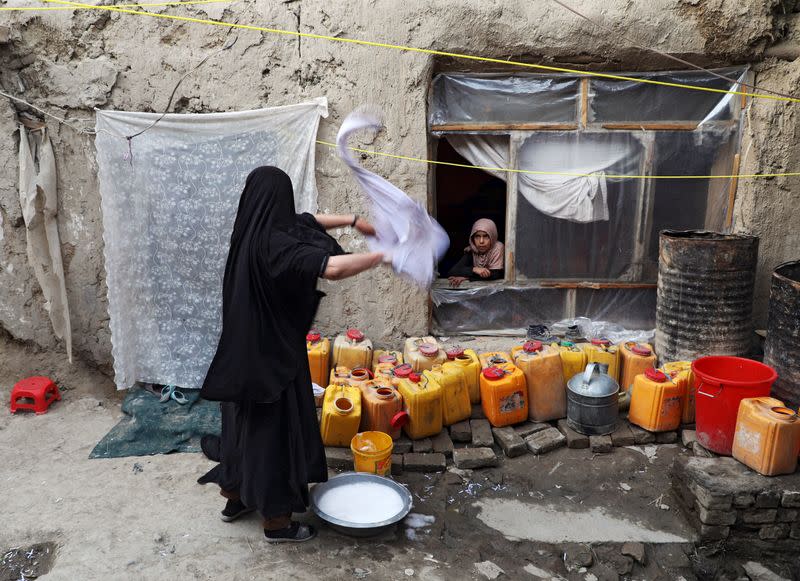 Delkhah Sultani, 30, an Afghan widow who lost her husband in a suicide attack almost six years ago, washes clothes as her daughter looks on in Kabul